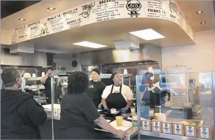  ?? Rick Loomis
Los Angeles Times ?? THE STAFF bustles behind the counter of Locol’s just- opened f irst location at Wilmington Avenue and East 103rd Street in Watts.