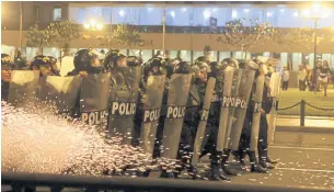  ?? REUTERS ?? Riot police officers hold their shields during an anti-government protest in Lima, Peru on Monday.