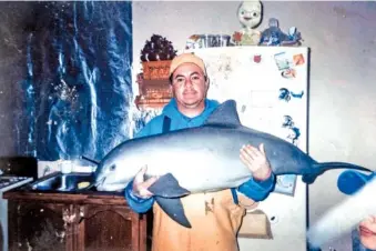  ?? THE ANGULO FAMILY VIA THE NEW YORK TIMES ?? A family photo shows Leonardo Angulo with a dead vaquita at his home in Santa Clara, Mexico, in 2004. Angulo said he found the animal floating at sea.