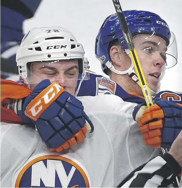  ?? ED KAISER ?? The Oilers’ Connor McDavid grapples with the Islanders’ Anthony Beauvillie­r Tuesday during New York’s 4-1 win at Rogers Place.