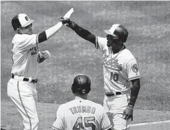  ?? GAIL BURTON/ASSOCIATED PRESS ?? The Orioles’ Manny Machado, left, is congratula­ted by Adam Jones and Mark Trumbo after hitting a two-run home run in the fourth inning. Kevin Gausman has been hurt by poor run support this season.