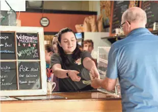  ?? PHOTOS BY SARA D. DAVIS FOR USA TODAY ?? Madeline Mondloch, 21, waits on a customer at the Scullery coffee house in Greenville, N.C. On the day of the Trump rally, owner Matt Scully donated all sales, more than $5,600, to the American Immigratio­n Council.