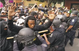  ?? John Minchillo / Associated Press ?? Police and protesters converge during a September demonstrat­ion in Louisville, Ky., after Breonna Taylor was fatally shot by police during a raid with a noknock warrant.