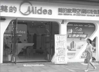  ?? LIU JUNFENG / FOR CHINA DAILY ?? A woman walks past a Midea flagship store in Yichang, Central China’s Hubei province.