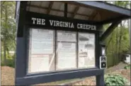  ?? KAREN TESTA — THE ASSOCIATED PRESS ?? A sign with the history of the Virginia Creeper at the entrance to a popular bike and hiking trail in Abington, Va. The 34-mile Virginia Creeper Trail, which stretches from Abington to Whitetop Station, Va., near the North Carolina border, began as a...