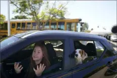  ?? Gregory Bull/Associated Press ?? Brooklyn Pittman talks as she sits in her car with her dogs after receiving food Oct. 28 from an Armed Services YMCA food distributi­on in San Diego.