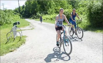  ?? Emily Matthews/Post-Gazette ?? Diana Repack, left, and Lisa Jacobs, both of Moon, ride their bikes Sunday on the Montour Trail in Robinson.