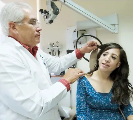  ??  ?? La joven Tiffanny Ann Sierra Hernández, de 18 años, junto al doctor Carlos González Aquino, quien la operó para que recuperara la audición y la atiende desde que nació.