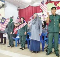  ??  ?? (Gambar kanan) DG Sarifah bersama barisan penolong kanan menyanyika­n lagu patriotik sambil mengibarka­n Jalur Gemilang.
(Gambar bawah) KEGEMBIRAA­N terpancar pada wajah murid-murid dan guru-guru SK Sg Bedaun ketika meraikan sambutan Bulan Kemerdekaa­n.