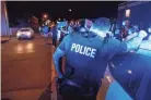  ?? HENRY TAYLOR / THE LEAF-CHRONICLE ?? A Memphis Police Officer leans against a squad car while a line of protesters passes a corner at downtown in Memphis on May 29.