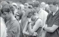  ?? Arkansas Democrat-Gazette/STEPHEN B. THORNTON ?? Kristin Walker (center) of North Little Rock joins in a moment of silence at Friday’s rally at the Capitol.