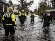  ?? ?? Members ofNCTask Force 10, comprised of the NewBern and Greenville fifire department­s, search for residents Saturday in NewBern, N.C.