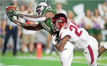  ?? PHOTO] ?? Colorado State wide receiver Preston Williams, left, reaches out to catch a touchdown pass as Arkansas defensive back Jarques McClellion defends. Arkansas squandered an 18 point lead in Colorado State’s 34-27 victory.[AP