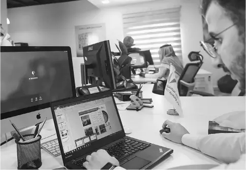  ??  ?? A picture taken on Aug 17shows a Saudi employee using a laptop to prepare a slideshow at his office in Riyadh.