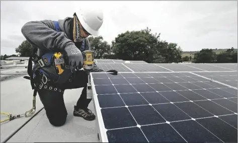  ?? BEN MARGOT/AP ?? GEN NASHIMOTO, OF LUMINALT, INSTALLS SOLAR PANELS IN HAYWARD, CALIF., on April 29, 2020.