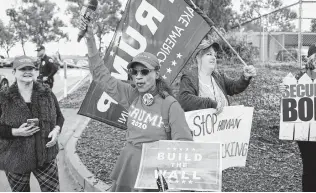  ?? Sandy Huffaker / Getty Images ?? Donald Trump pledged Mexico would pay for the wall, but his supporters, such as these in San Ysidro, Calif., don’t care. They care only that the wall is built; that’s why Trump can’t back down.