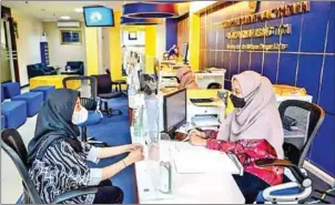  ?? ANTARA/M RISYAL HIDAYAT ?? A staff worker consults a taxpayer at a tax office in Jakarta on Saturday.