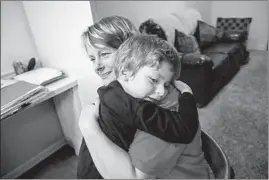  ?? ZBIGNIEW BZDAK/CHICAGO TRIBUNE ?? Laura Myers hugs her son, who does not speak but can sign a few words, before bedtime in their Centralia home. Myers said she spoke with an ISBE investigat­or for 13 minutes.
