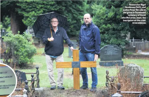  ?? PETER MORRISON ?? Researcher Nigel Henderson (left), and author Peter Mccabe at the grave in Dundonald
cemetery of David John Mccarron. Inset, the
inscriptio­n on the cross