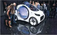  ?? UWE ANSPACH/DPA VIA AP ?? Visitors stand next to a Smart ‘Vision EQ’ on the first press day of the Frankfurt Internatio­nal Motor Show IAA in Frankfurt, Germany, on Tuesday.