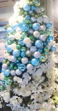  ??  ?? An Enchanted Christmas theme evokes magic with a green tree, blue and white balls interspers­ed with flowers and foliage.