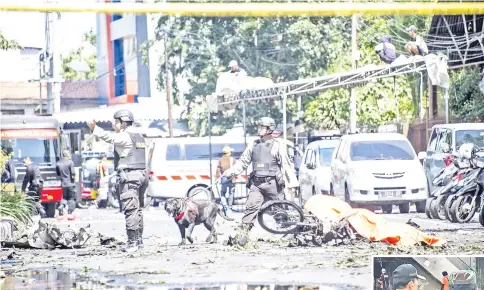  ??  ?? K9 police examine a site following attacks outside the Surabaya Centre Pentecosta­l Church (Surabaya Gereja Pantekosta Pusat) in Surabaya. — AFP photo