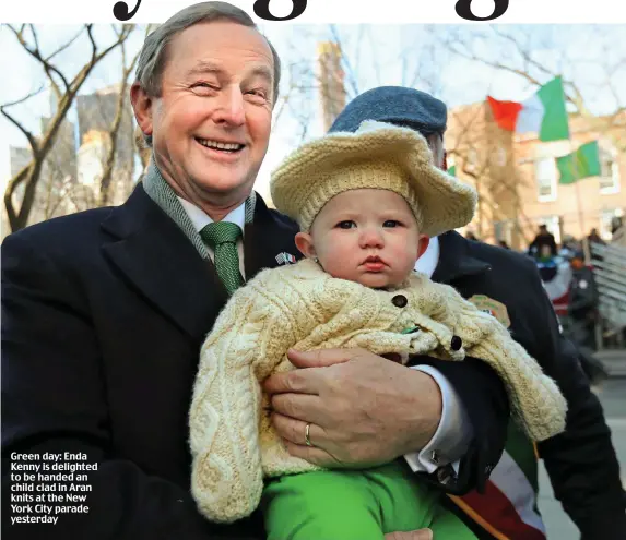  ??  ?? Green day: Enda Kenny is delighted to be handed an child clad in Aran knits at the New York City parade yesterday