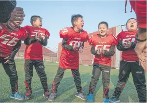  ??  ?? Students at the Real Boys Club shout the club’s pledge at a football practice in Beijing. Club founder Tang Haiyan offers a programme that appeals to parents who worry that their sons are becoming too soft.