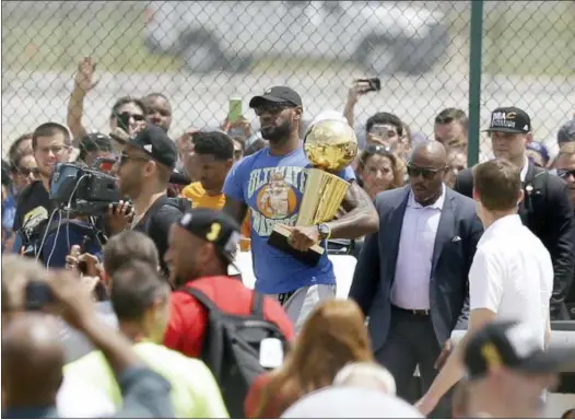  ?? TONY DEJAK — ASSOCIATED PRESS ?? The Cavaliers’ LeBron James carries the NBA Championsh­ip trophy after arriving in Cleveland on June 20, 2016.