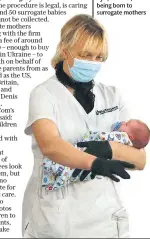  ??  ?? A nurse with one of at least 50 babies stranded at Biotexcom’s Hotel Venice clinic in Kyiv, Ukraine, after being born to surrogate mothers