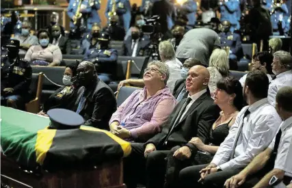  ?? Picture: MARK ANDREWS ?? SAD LOSS: Michalene Marx and Andries Marx watch photos being displayed on a large screen as band members play in the background. SAPS captain Pierre Marx was given a hero’s send-off on Saturday as colleagues, friends and family gathered to pay tribute to the legendary K9 search & rescue member at the Calvary Christian Church in Quigney