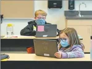  ?? (AP/Ted S. Warren) ?? Students wear masks as they work in a fourth-grade classroom at Elk Ridge Elementary School in Buckley, Wash.