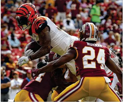  ?? ALEX BRANDON / ASSOCIATED PRESS ?? Running back Jeremy Hill dives into the end zone past Redskins cornerback Josh Norman to cap an 87-yard, 15-play drive as the Bengals take a 7-0 lead. Hill left in the first half with an ankle injury after gaining 15 yards on five carries.