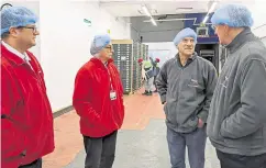  ?? ?? Members of the delegation speak to bosses at the fruit producer during their visit