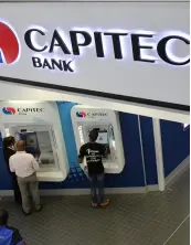  ?? ?? ▲Customers queue to draw money from an ATM outside a branch of South Africa’s Capitec Bank in Johannesbu­rg,South Africa.