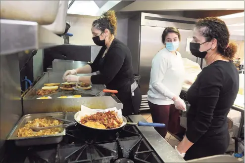  ??  ?? Owners Amal Johnston, right, and her daughter Dalia Ghossaini, left, prepare breakfast sandwiches.