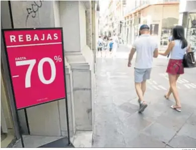  ?? CARLOS GIL ?? Un cartel anuncia las rebajas de verano del pasado año en una calle de Granada.