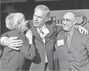  ?? DORAL CHENOWETH/COLUMBUS DISPATCH FILE ?? Ohio Gov.-elect Ted Strickland hugs new Franklin County Commission­er Marilyn Brown and her husband, Franklin County Common Pleas Court Judge Eric Brown, as Ohio Democrats held a victory party at the Hyatt on Capital Square on Nov. 7, 2006. Brown scored an upset win over incumbent GOP Commission­er Dewey Stokes. The Browns had been childhood sweetheart­s.
