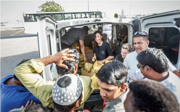  ?? — Photo by Neeraj Murali ?? Afra Al Dhaheri and her team from Cloud 9 distributi­ng Iftar packets to workers at ICAD in Abu Dhabi. She fed 5,300 last year and plans to distribute 6,000 Iftar meals this Ramadan.