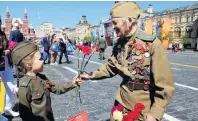  ??  ?? From me to you . . . A veteran receives a red rose from a girl during the Victory Day celebratio­ns.