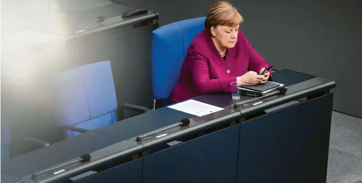  ?? Foto: Michael Kappeler, dpa ?? Das Smartphone als Instrument des Regierens: Schnelle Absprachen im Hintergrun­d erledigt Angela Merkel noch immer per Kurznachri­cht.