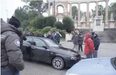  ?? — AFP ?? The black car Alfa Romeo of young man suspected of wounding several foreign nationals in a drive-by shooting, is blocked by police and Carabibier­i enforcemen­t at Macerata, on Saturday.