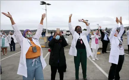  ?? JANE TYSKA — STAFF PHOTOGRAPH­ER ?? Health care workers react as four F-15C Eagle fighter jets from the California Air National Guard’s 144th Fighter Wing fly over the Kaiser Permanente Richmond Medical Center in Richmond on Wednesday.