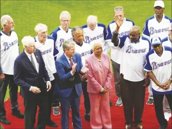  ?? JOHN BAZEMORE/AP ?? BILLYE AARON, wife of the late Hank Aaron stands with Georgia Gov. Brian Kemp (second from left) Atlanta Braves chairman and CEO Terry Mcguirk (left), Dusty Baker (right) and players from the 1974 Atlanta Braves team during a ceremony to mark the 50th anniversar­y of Aaron breaking Babe Ruth’s home run record team before a game against the New York Mets on Monday in Atlanta.