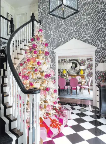  ?? Nancy Nolan ?? Traditiona­l Home Graphic wallpaper and a classic black-and-white porcelain checkerboa­rd floor are the backdrop for a tree decked out in a mix of gleaming hot pink, pink, gold and silver ornaments. The pinks pick up hues from the azalea velvet chairs in...