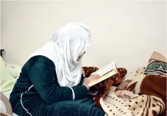  ?? ?? إحدى النزيلات تقرأ القرآن داخل الدار فى ظل أجواء رمضانية