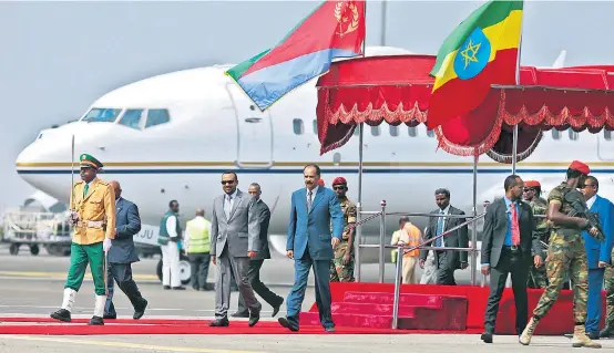  ??  ?? Eben noch spinnefein­d, wird Eritreas Präsident Isaias (Mi.) nun vom äthiopisch­en Premier Abiy (li.) mit militärisc­hen Ehren empfangen.