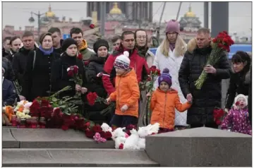  ?? Dmitri Lovetsky/Associated Press ?? People lay flowers at a spontaneou­s memorial Sunday in St. Petersburg, Russia. The country observed a national day of mourning on Sunday, two days after an attack on a suburban Moscow concert hall killed more than 130 people.