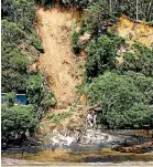  ?? RYAN ANDERSON/STUFF ?? An elderly woman was trapped after a landslide took out a holiday home on Orua Bay Beach on Wednesday.