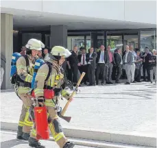  ?? FOTOS: SIMON SCHNEIDER ?? Hinten warten die geladenen Gäste, doch die Feuerwehrl­eute suchen erst nach der Ursache des Brandalarm­s am Sparkassen­forum. Er stellte sich als Fehlalarm heraus.